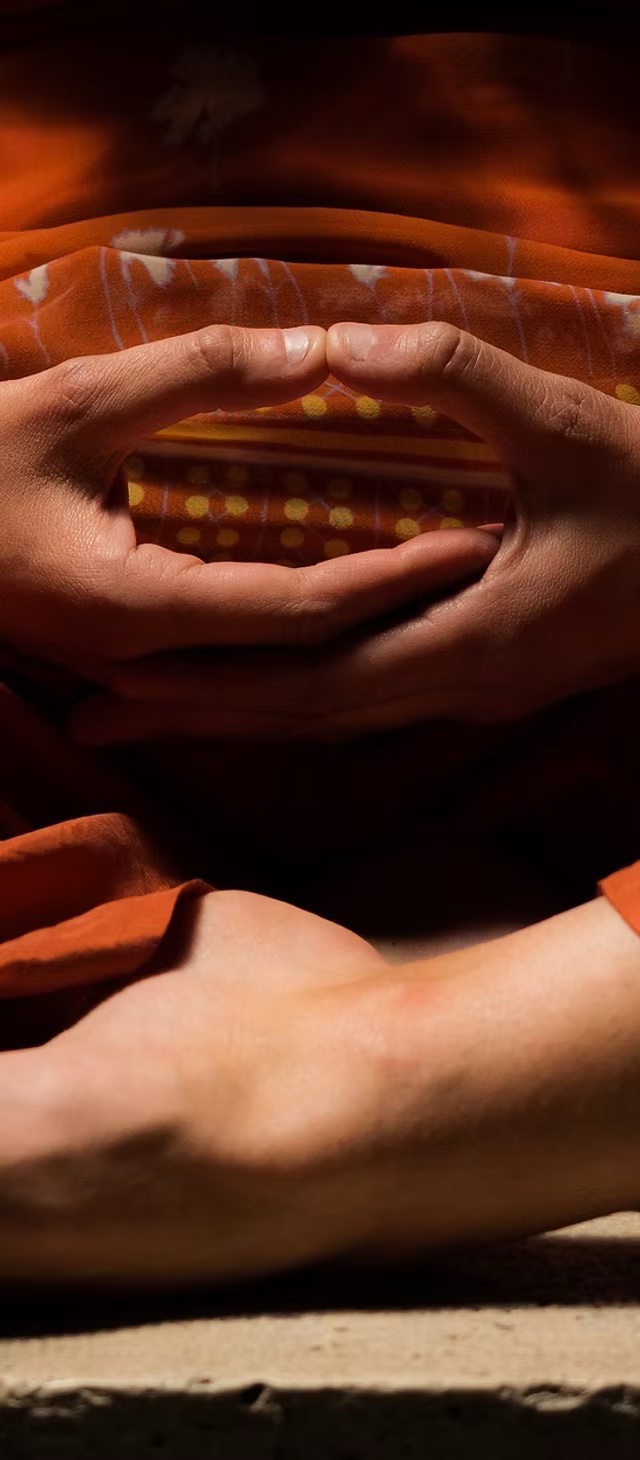 Hands resting together in a meditation gesture